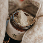 Close‑up of Alta Fauna aluminum‑free tallow deodorant. Amber glass jar with a spoon shows the deodorant outside of the jar. 