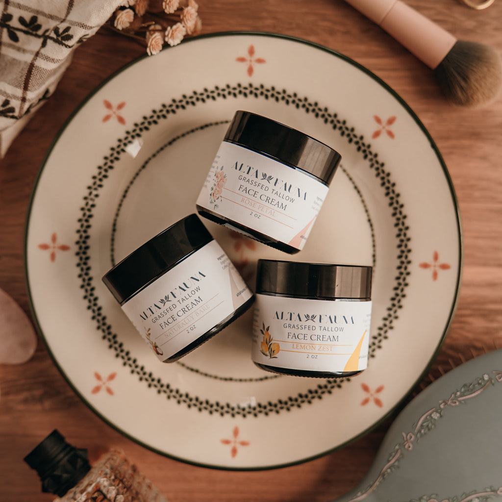 Three jars of Alta Fauna face cream on a decorative plate with a wooden background.