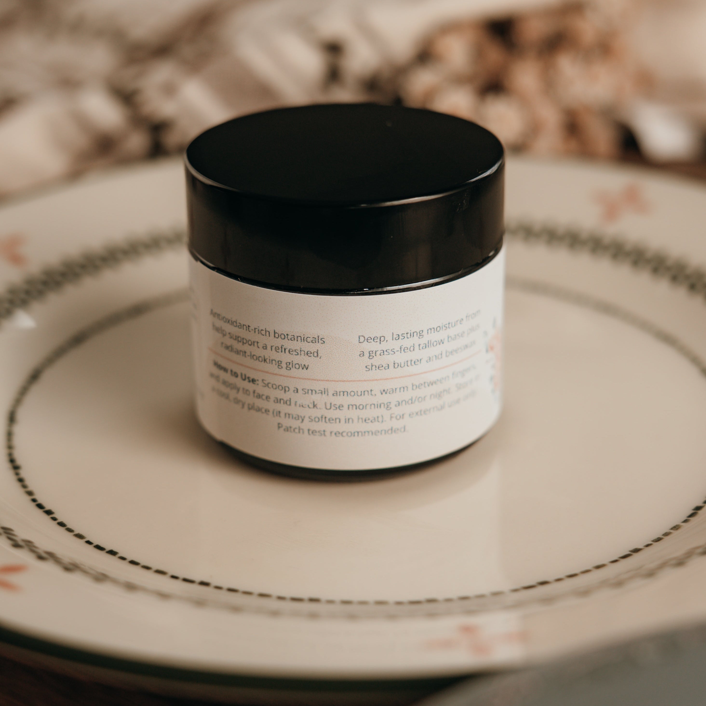 Alta Fauna Face Cream on plate showing the back of the jar including how to use and ingredients.  