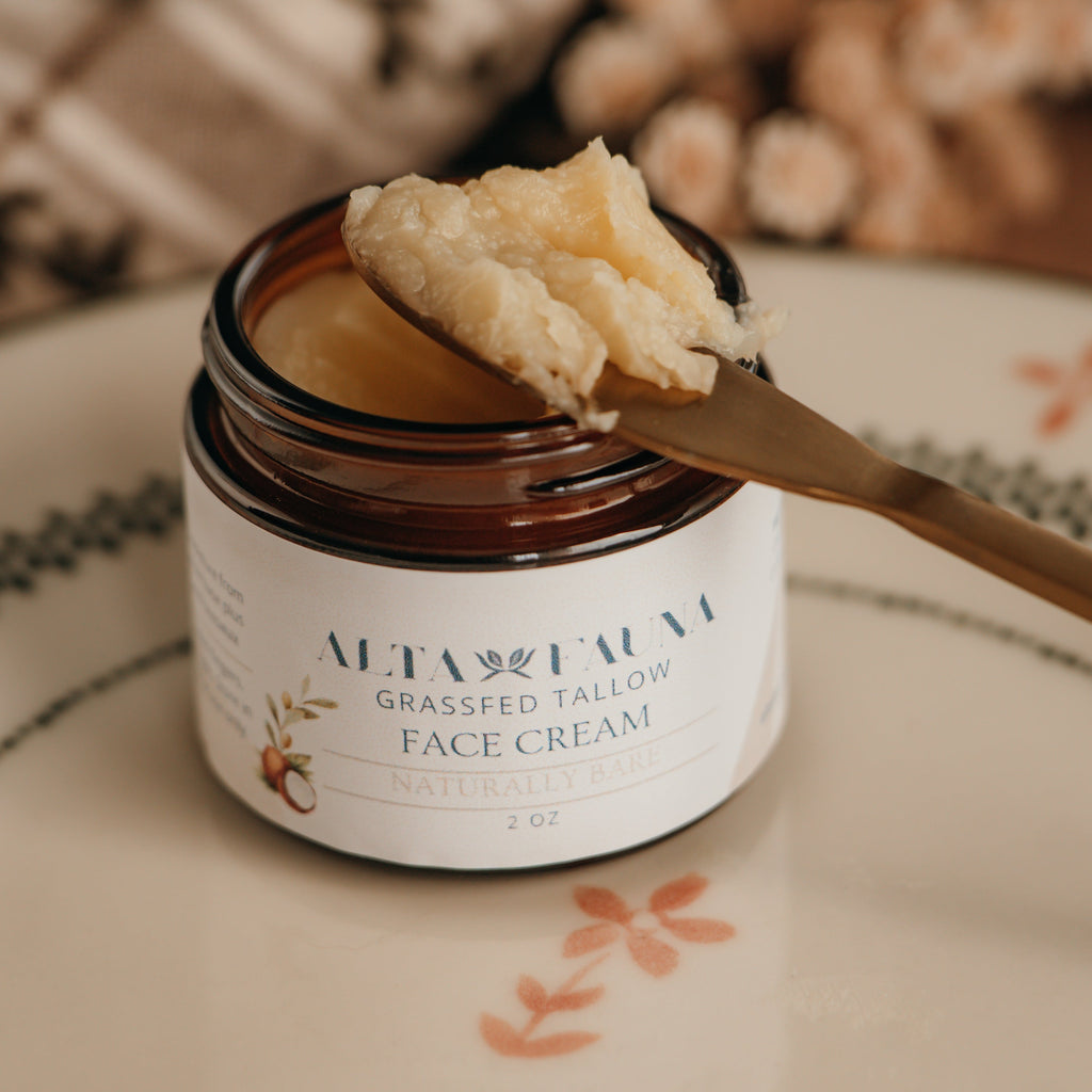 Jar of Alta Fauna face cream on a plate with a spoon. Jar is open and the cream is on a spoon showing the texture. Close up of the label.