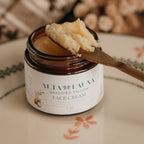 Jar of Alta Fauna face cream on a plate with a spoon. Jar is open and the cream is on a spoon showing the texture. Close up of the label.