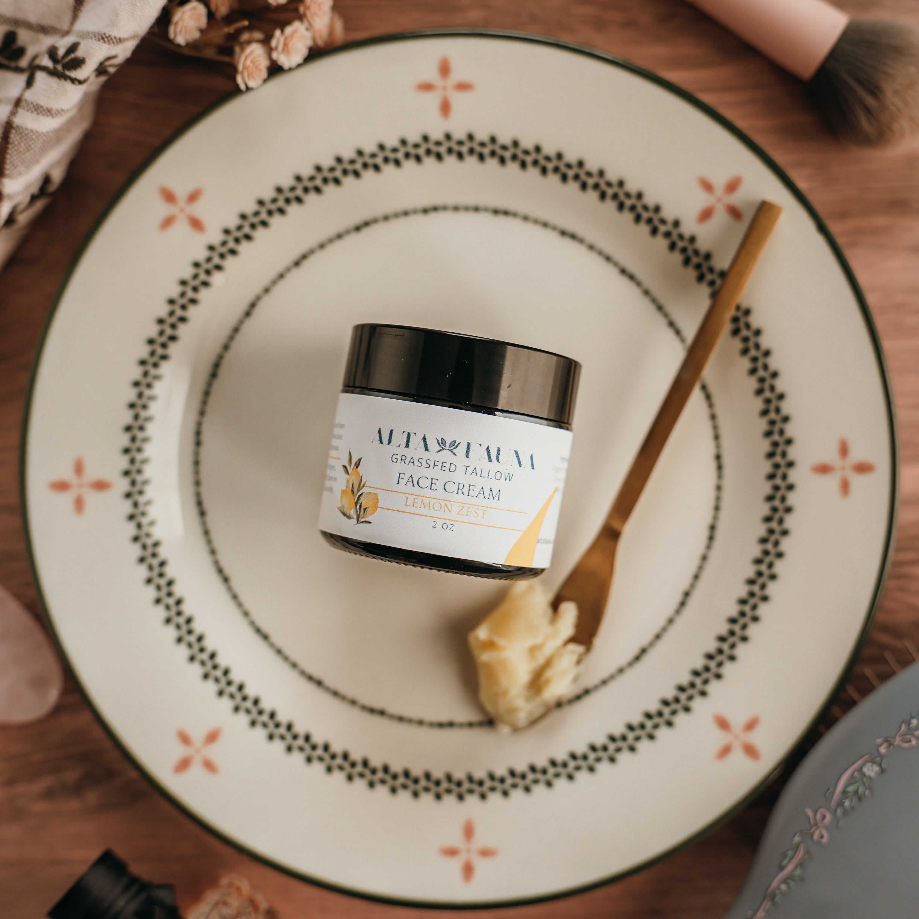 Jar of Alta Fauna face cream on a plate with a spoon. Jar is closed and the cream is on a spoon showing the texture.