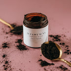 Jar of Alta Fauna Charcoal & Clay Face Mask with black powder on a pink background