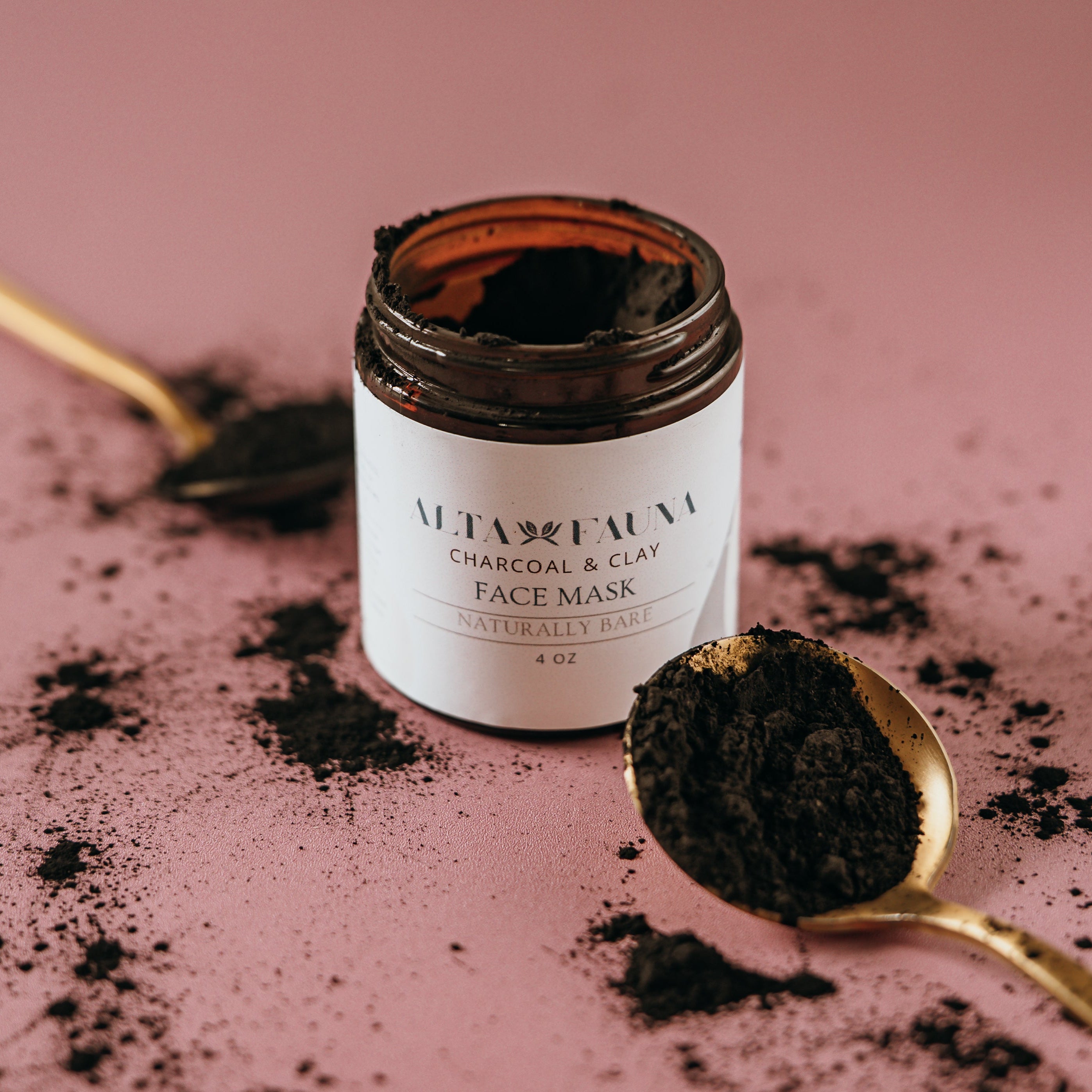 Jar of Alta Fauna Charcoal & Clay Face Mask with black powder on a pink background