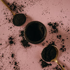 Gold spoons and glass, amber jar with Alta Fauna charcoal and clay face mask powder.