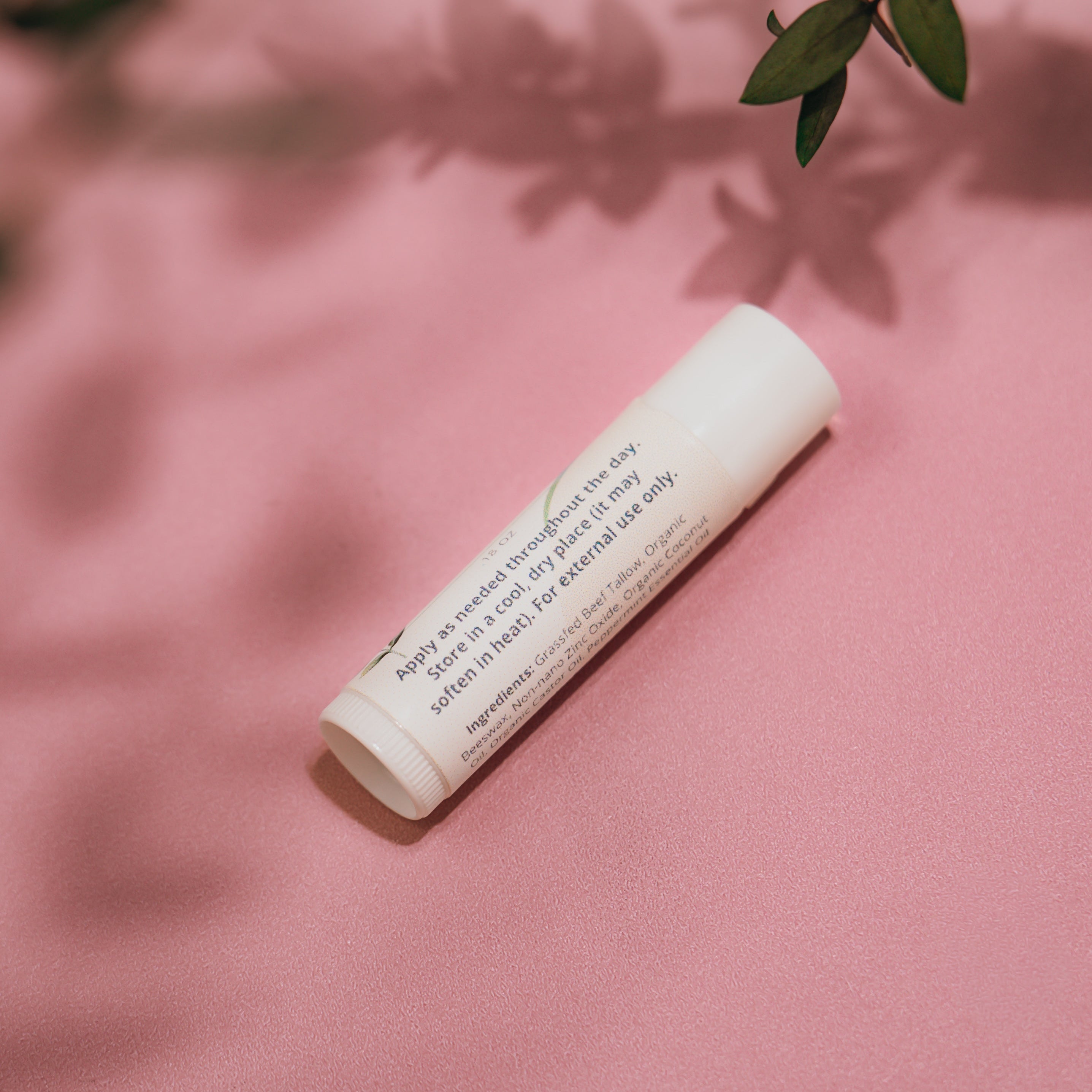 Close‑up of Alta Fauna Grassfed Tallow Lip Balm with mineral zinc for protective daily lip care. Close up of label and ingredients.