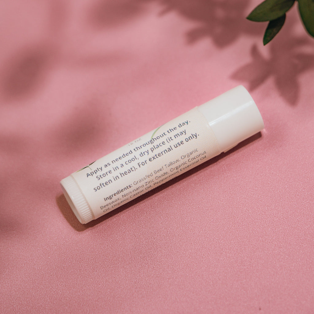 Close‑up of Alta Fauna Grassfed Tallow Lip Balm with mineral zinc for protective daily lip care. Close up of label and ingredients.