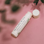 Close‑up of Alta Fauna Grassfed Tallow Lip Balm in Peppermint with mineral zinc for protective daily lip care. Close up of tube and lip balm texture on pink background.