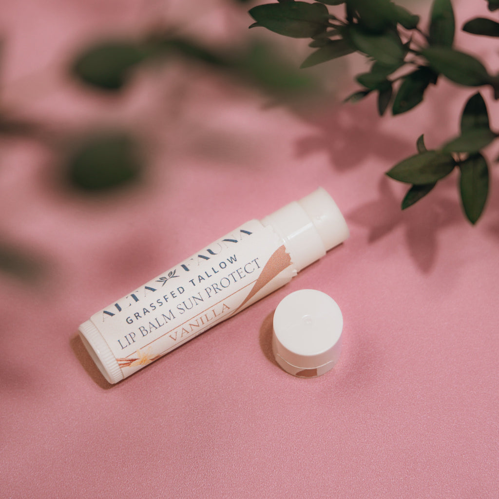 Close‑up of Alta Fauna Grassfed Tallow Lip Balm with mineral zinc for protective daily lip care. Shown in vanilla on a pink background.