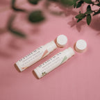 Alta Fauna Vanilla and Peppermint Lip Balms with Sun Protect together with caps off on pink background.  Texture of lip balm shown. 