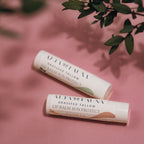 Alta Fauna Vanilla and Peppermint Lip Balms with Sun Protect together with caps on, on a pink background.  