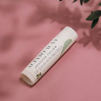 Alta Fauna Peppermint Lip Balm with Sun Protect with lid on a pink background.  Texture of lip balm shown. 