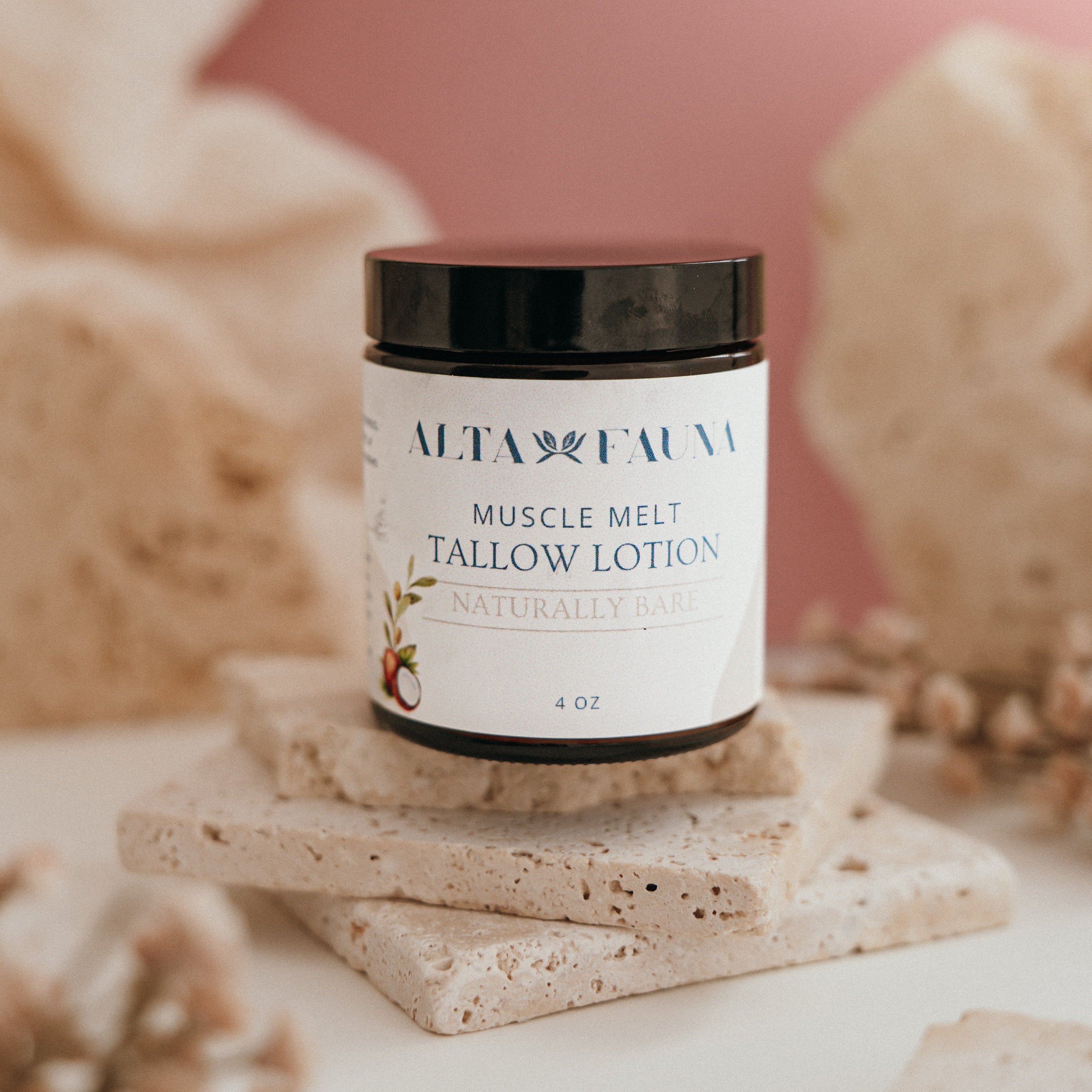 Alta Fauna Muscle Melt Tallow Lotion in Naturally Bare - Unscented (4oz) pictured on a stack of granite with a light pink background.